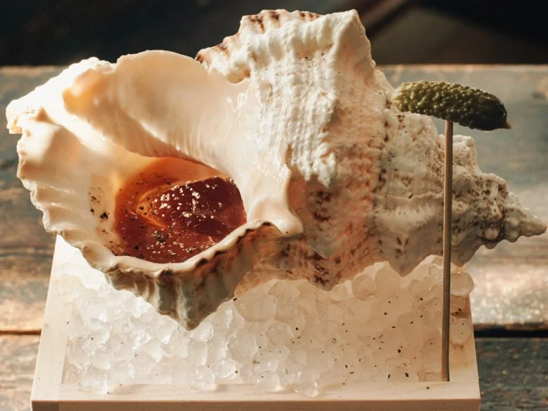 ROKC’s owner and beverage director, Shige Kabashima, took on the classic Clamato at his restaurant (which stands for Ramen, Oyster, Kitchen, Cocktails). The blend of tomato juice, clam juice, mezcal and wasabi is poured over ice and served in a seashell set over an ice-filled wooden box, garnished with a cornichon. 