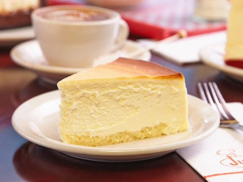Cheesecake was part of the world's culinary canon long before the towering metropolis of New York City staked its claim -- cakes of soft cheese go all the way back to ancient Greece. However, an American created the breakthrough that would become New York Cheesecake. In an attempt to replicate French Neufchatel cheese, a man named William Lawrence of Chester, New York, stumbled upon an even richer and creamier un-ripened result. That cream cheese became the base for New York's simple cheesecake (along with cream, eggs and sugar), which grew in popularity through the early 20th century. The most-venerable rendition came out of the Junior's kitchen in downtown Brooklyn in 1950, resulting in a dense, smooth and almost pungent dessert that still attracts fans from throughout the region and around the world.