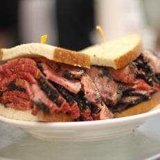 Pastrami is made by curing meat with salt and spice, then smoking and steaming it until tender. It was brought to NYC by Romanian Jews in the late 1800s, during a period of mass Eastern European immigration. Many of those newcomers opened kosher delis and somewhere along the way, the combination of hot, sliced beef pastrami and spicy brown mustard on lightly seeded rye bread was born. Although hundreds of Jewish delicatessens opened in the late 19th and early 20th centuries, one of the oldest remaining is Katz’s Deli on the Lower East Side. Opened in 1888, the cash-only cafeteria-style icon is a local and tourist favorite for its towering hand-cut hot pastrami sandwiches, sliced by gruff cutters, many of whom live in the neighborhood. It’s as classic a New York City experience as one can find.
