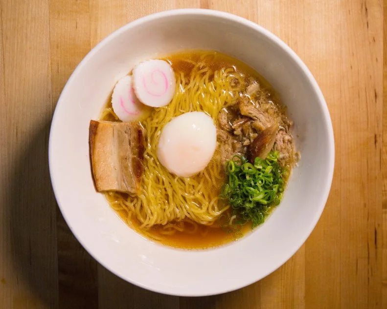 David Chang did not invent ramen: He merely sparked a national obsession. In 2004, he opened the doors to Momofuku Noodle Bar, spreading the ramen-ya gospel to NYC. His stark storefront follows the traditional Japanese format, with counter dining, late-night hours, booming music, no reservations and lots of pork. Thanks to his quality product and runaway popularity, similar shops can now be found across the United States. His signature bowl has been tweaked and modified since its inception, at one point using Benton’s bacon dashi. These days, springy noodles are topped with pork belly, pork shoulder, a poached egg, scallion, nori, bean sprouts and a fish cake.