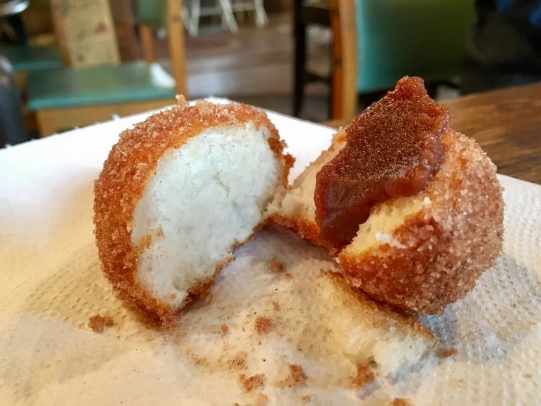 Now, these aren’t what you probably think of as biscuits — they’re more of a deep-fried bread dough — but the fluffy, cinnamon- and sugar-covered treats have become something of a Nashville, Indiana, specialty. At the kitschy Nashville General Store & Bakery, the dough is made from scratch, rounds are fried to order, then each is tossed in cinnamon and sugar and served with apple butter, which really isn’t butter, but rather a rich, dark, spiced-apple spread.