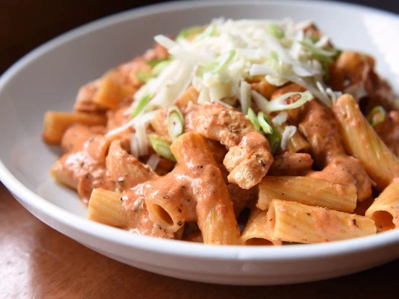 Pasta has long been a staple in New York. One of America’s most-influential restaurants, Mamma Leone’s, was the first Italian restaurant to gain a serious following when it opened around the turn of the century. The ties between the Empire State and red sauce run deep. Up in Utica, the usual spaghetti and meatballs gives way to a unique regional specialty, chicken riggies. Rigatoni (i.e. riggies) are mixed with chicken and hot or sweet peppers in a spicy cream and tomato sauce. The dish is so popular and so beloved that it has its own festival, Riggie Fest. Many locals have a favorite, but when Guy came to town on Triple D, he dove into the Wicky-Wicky Chicken Riggies at Pastabilities, under scallions and freshly grated cheese.