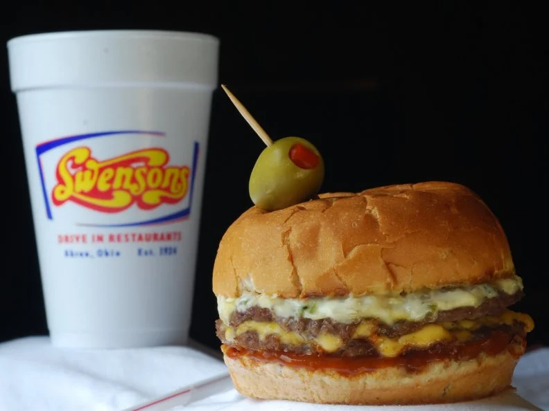 In Akron (and surrounding communities), the drive-in is alive and well. Fans of Swenson’s know that when they pull into any one of the restaurant’s handful of locations, they’ll be promptly greeted by enthusiastic “curb servers” who sprint between car and café. Flick your lights on for service, order a Galley Boy, onion rings and a creamy chocolate milkshake, and you’ll be rewarded with a classic diner meal dished up on a carhop tray affixed to the car window. Since 1934, drivers and passengers have loaded up on beloved Galley Boys, a sandwich composed of twin diner-style patties, melted cheese and not one, but two special sauces on a soft bun. The bundle is swaddled in a wax-paper pouch and garnished with an olive-topped toothpick.