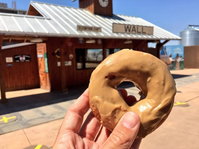 Few visits to Mount Rushmore are complete without a stop at Wall Drug Store for maple-glazed doughnuts. Open since 1931, the pharmacy-cum-soda-fountain used to lure travelers with its water, not its pastries. Wall Drug is located on the edge of South Dakota's Badlands, and people crossing the prairie in the warm summer months appreciated cold drinks. All it took was a billboard on the highway proclaiming "Free Ice Water," to lure people in. Once inside and hydrated, visitors took to the other menu items; namely the ice cream and the soda fountain have been notable favorites ever since. Today, Wall Drug draws 1 million visitors a year who come for the 5-cent coffee, bison burgers, homemade chocolate fudge and vast selection of cowboy boots.