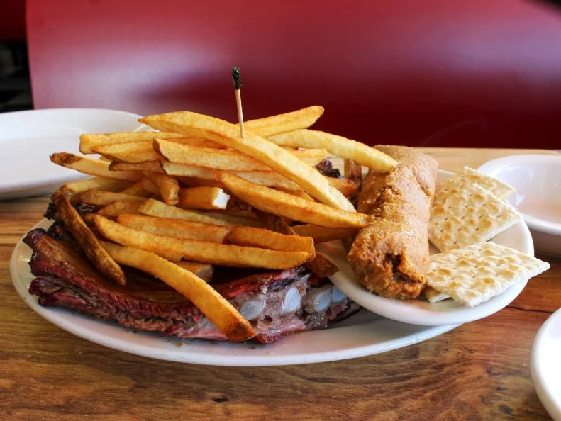 Legendary McClard’s Bar-B-Q smokes meat in the childhood town of former president William Jefferson Clinton. Lore says that a weary traveler staying at Alex and Gladys McClard's Westside Tourist Court could not afford to pay his rent. The most-valuable possession he could offer instead was his secret hot sauce recipe. Rather than receive nothing at all, the McClards accepted his offer. After lacquering their goat meat with this best-tasting sauce, they officially changed their Westside Tourist Court housing into Westside Bar-B-Que. In 1942 the McClards tweaked the name when they moved the operation to its current home; in 2006, nearly 80 years after opening, the restaurant catered the 42nd president's 60th birthday celebration.