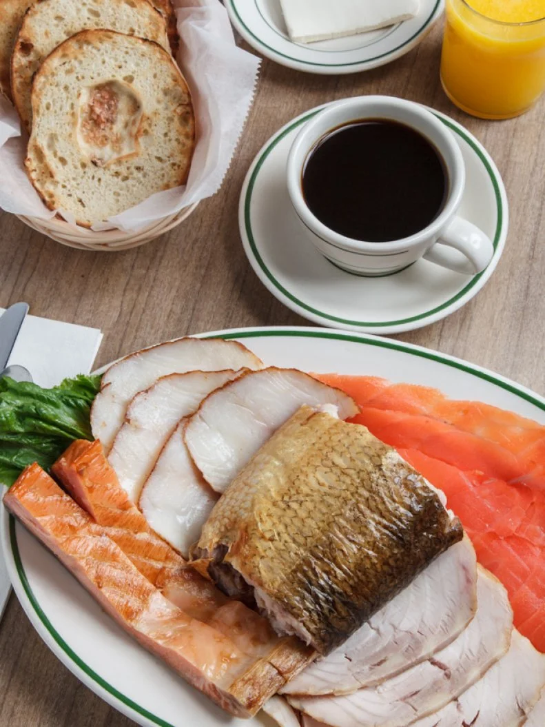This classic New York delicatessen and Upper West Side institution has been sporting the same wallpaper and Formica tables since moving to its "new" digs in 1929. Dubbed "the Sturgeon King" for his smoked fish prowess, Barney Greengrass died in 1956, to which Groucho Marx remarked, "He may not have ruled any kingdoms or written any great symphonies, but he did a monumental job with sturgeon." Considered the primo fish, the Greengrass sturgeon is imported from the lakes of northern Canada, skinned, boned and gently smoked in-house, then sliced to order. But the sturgeon is not the only favorite. Barney Greengrass is the go-to spot for fresh bagels with cream cheese and smoked salmon (nova, lox and gravlax are all available), whitefish salad, chopped liver, and the savory lox, onions and eggs. Lines on weekend mornings stretch out to Amsterdam Avenue, proving fans have never stopped worshipping this temple of smoked fish.