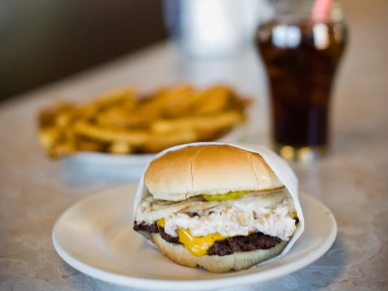 Carhops and waitresses at the 16-seat, U-shaped lunch counter of Matt’s Place Drive-In in Butte still serve milkshakes made from house-churned ice cream, and hand-cut fries, along with the notorious Nut Burger, a 100 percent lean Montana patty cooked on a cast iron grill and topped with a mixture of mayo, chopped cashews and pecans. When the James Beard Foundation bestowed a 2016 America’s Classics Award to the drive-in, it called the Nut Burger a “masterpiece [whose] topping melds with sliced pickles, tomatoes, and onions righteously.”