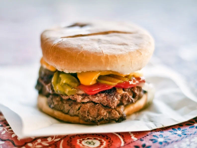 Catholic Burgers are available for but a fleeting moment the second weekend of July at the Wolf Point Wild Horse Stampede on Montana’s Fort Peck Indian Reservation. Sold 24 hours a day from a stand with a perpetually long line, the treats were conceived in 1947 as a fundraiser for the Immaculate Conception Parish. Working around the clock in four-hour shifts, spatula-wielding volunteers keep a watchful eye on grills laden with local beef and onions sizzled in pickle juice, which aficionados ask for piled high on top.