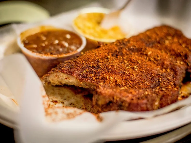 While there's nothing technically wrong with slathering a slab of spare ribs with sauce like they do in other states, Memphis barbecue fans have learned to complement the flavor of the pork with a dry rub instead of concealing it under sweet, sticky sauce. The Vergos family revolutionized ribs by developing a spice mix based on the rubs their Greek ancestors used to flavor lamb. At their Rendezvous restaurant, they still serve hundreds of racks every day cooked over charcoal and seasoned with their proprietary rub.