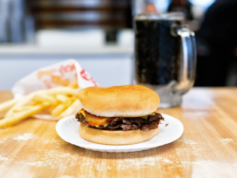 Carl’s Drive In opened in 1951 and has been the king of the smashed burger ever since. The patties are so thin, so crispy, and so delicious, that there are lines out the door at this 16-seat restaurant every single day, rain or shine. Don’t feel bad about ordering a double or triple cheeseburger: each patty is only about one-sixth of a pound. Complete the full Carl’s experience by getting a big, frosted mug full of their housemade root beer.