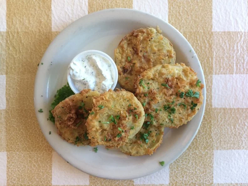 A summertime favorite across the South, fried green tomatoes are ideal straight from the garden. After that, Mama Dip’s in Chapel Hill is the next-best option. Diners have the option of a small or a large serving of sliced green tomatoes, dredged in cornmeal, fried to crispness and served piping hot. That might make some people wonder: Is this dish so good that you’d want to eat double the amount of any other vegetable? The answer is yes. Nicknamed Dip for her long arms that could reach the bottom of a water barrel, Mildred Council has been cooking for her entire life. In 1976, she opened Mama Dip’s in the heart of Chapel Hill’s college community. Two acclaimed cookbooks and several branded products later, Mama Dip still lures home-cooking fans to her restaurant for the best fried green tomatoes anywhere.