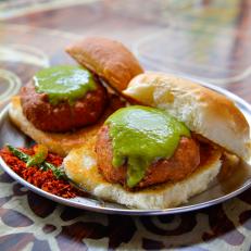 Chi Pani's signature dish, Vada Pav, Spicy potato dumplings fried in curried chickpea batter topped with green & tamarind chutneys served on two toasted buns, as seen on Food Network's I Hart Food, Season 1. 