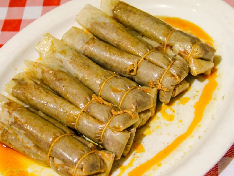 Once a culinary oddity barely known outside the state, the Mississippi hot tamale has been getting lots of attention lately. Moister and often spicier than their Mexican ancestors, these savory, oily treats comprise cornmeal dough encasing ribbons of well-seasoned meat, which are then wrapped in corn husks or parchment, tied in bundles and simmered — rather than steamed — in savory broth. Typically, they are served with Saltines and small cups of chili on the side. Most of the tamale makers today are descendants of African-American sharecroppers who likely got their first taste from Mexican laborers working beside them in the cotton fields more than a century ago, and then improvised the technique. Doe’s Eat Place, the nationally celebrated steak house run by an Italian family in a proudly shabby former grocery store in Greenville, has been serving parchment-wrapped tamales as an appetizer for generations based on their own hand-me-down recipe. Each year, vendors from all over the region gather in Greenville for the annual Delta Hot Tamale Festival to compete for trophies and invite visitors to taste their creations.