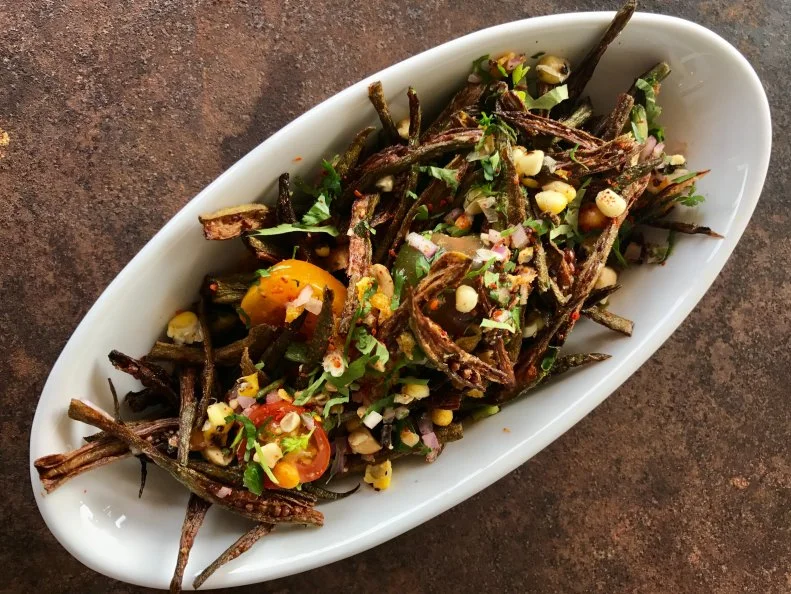 Mississippians consume huge amounts of these tough-skinned pods, usually when they’ve been sliced into rounds, dredged in cornmeal and fried into crunchy nuggets. Vishwesh Bhatt, executive chef at Snackbar in Oxford, earned a James Beard Foundation Award nomination by fusing Southern ingredients and techniques from his native India, including his okra chaat: thin lengthwise slices of flash-fried okra, tossed with a melange of chopped tomatoes, peanuts, cilantro, chiles, lime juice and Indian spices. On the entrée side, he simmers okra in a skillet with corn to go with fried catfish and basil chutney.