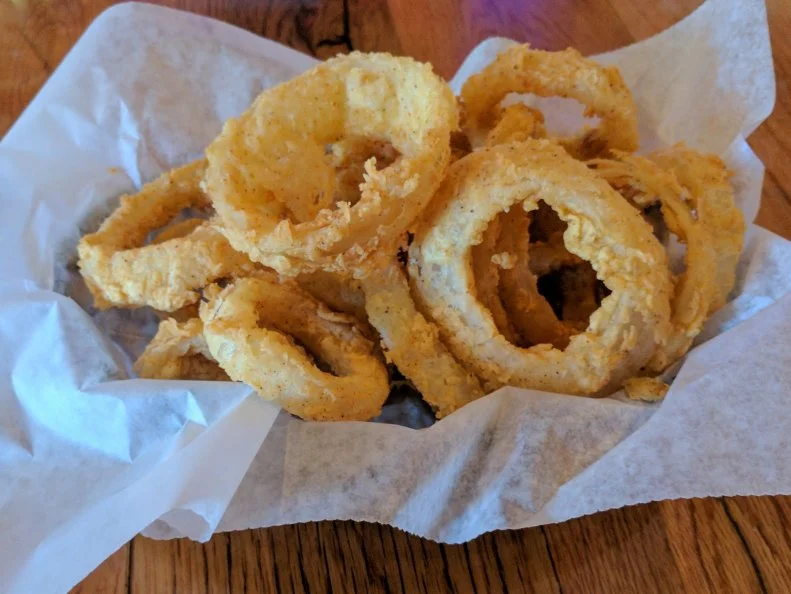 If you’re in the mood for both a scenic road trip and a great onion ring, head toward The Rustic in Fort Calhoun, where the onion rings come hot, crispy and heaping over their baskets. The delicate, peppery breading clings to the sweet, melty interior, transforming the lowly vegetables into something sinfully good. Be sure to get a side of the homemade ranch dressing for dipping.