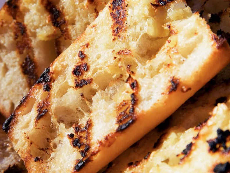 When a steak restaurant in Nebraska’s Sand Hills professes to do something else as well as it does red meat, you should order it. That’s the case with the garlic bread at the Peppermill Steakhouse, in Valentine. The crusty garlic bread comes thick-cut, seasoned with fresh herbs and rubbed with garlic; char marks cover both sides and lend a delicious grilled flavor. It traditionally comes with bright marinara sauce for dipping, but the menu mentions that the kitchen is happy to substitute that for a bowl of meaty beef au jus for dipping instead, which, frankly, is a terrific idea.