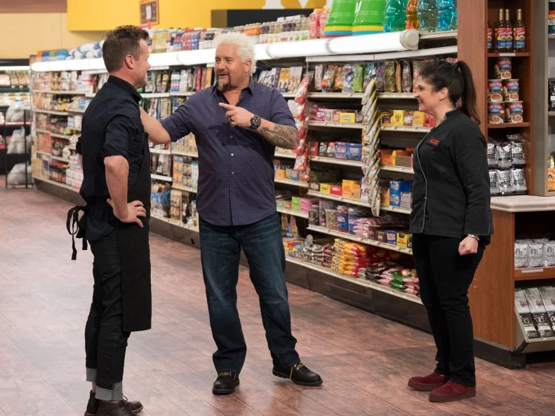 Host Guy Fieri welcomes Contestants Brian Malarkey and Alex Guarnaschelli, as seen on Guy's Grocery Games, Season 14.