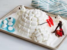 Kids will love helping create this easy and fun-to-make arctic scene. A vanilla cake, filled with a sweet, delicious layer of marshmallow crème, gets piled with marshmallows to make it look like an igloo. Puffy polar bears and roasting gummy fish make cute edible decorations.