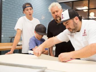 (L to R) Hunter, Ryder, and Guy Fieri observe as owner and chef, David CÃ¡ceres, uses a sharp knife and ruler to make exact cuts in the croissant dough at La PanderÃ­a cafe in San Antonio, Texas, as seen on Diners, Drive-Ins, and Dives, Season 27.