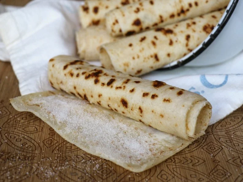 Lefse is a Norwegian-American staple. The flat potato bread is best enjoyed with a spread of butter and, for the sweet tooth, sprinkled with sugar, and rolled up. Scandinavian grandmas, aunts and moms are keepers of the family recipe and, when grandma is ready to give it up, they inherit the lefse grill, turning stick and corrugated wooden rolling pin. Lefse is iconic to South Dakota but it, and similar dishes influenced by Norwegian culture such as krumkake, sandbakkels and rosettes, are made in home kitchens, not restaurants. When you must venture out of grandma’s kitchen, buy packaged lefse at participating Hy-Vee stores or at bakeries and church bake sales at Christmastime.