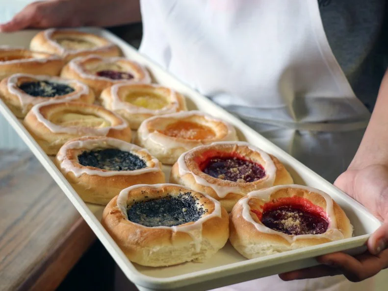 “My grandma’s kolaches are the best,” is what you’ll hear at Czech Days in Tabor and across the lower east half of South Dakota. The recipes are secret and families are competitive about whose is best. Tyndall Bakery uses a kolache recipe original to the bakery. Before the soft yeast dough is baked, the pastry center is filled with a generous dollop of sweet filling like cherry, apple, lemon, poppyseed, cream cheese, strawberry-cream cheese, apricot or prune. Once out of the oven, it is drizzled with glaze and sprinkled with a hint of streusel. Eat kolache around the circle so you have filling in every bite.