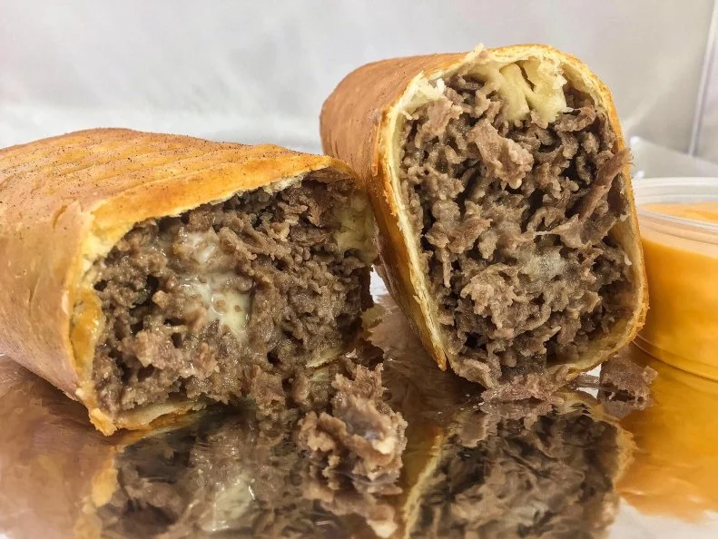 Boredom and a love for fried foods gave Hoagie Xpress owner Chalie McDonald the idea for this deep fried take on the iconic Philly cheesesteak. The City of Brotherly Love's namesake sandwich usually combines paper thin slices of beefsteak with melted cheese â   preferably Cheez Whiz â   in a hoagie roll. While standing around on one cold winterâ  s day in nearby Levittown, Pennsylvania, McDonald decided to forego the bread, sticking thinly sliced griddled beef with American cheese in a wrap, plunging the whole thing in bubbling oil and adding an extra side of liquid cheddar for dipping. The result might just be better than the original, if such a thing is possible.