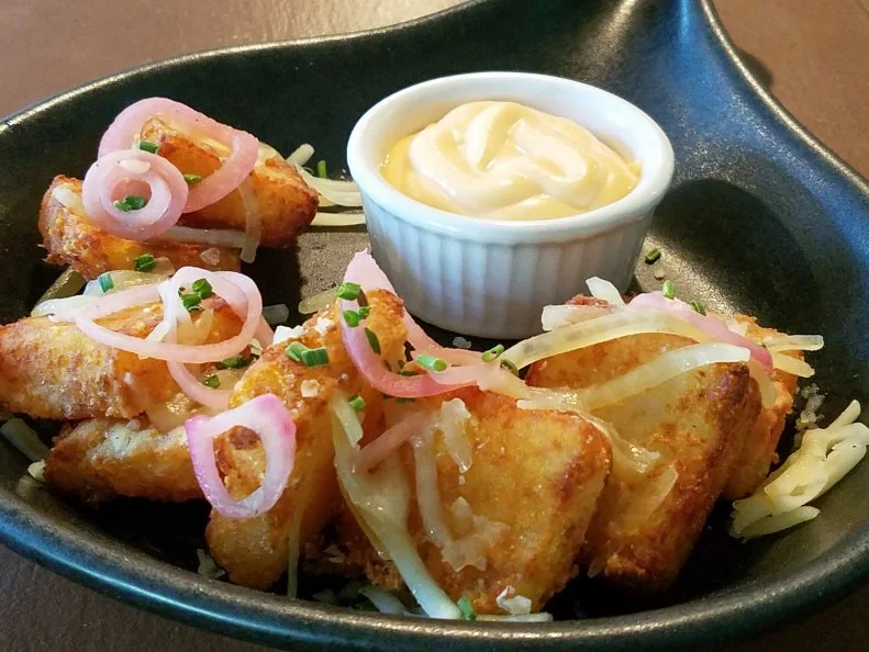 Vermont is known for its impeccable dairy products, including cheddar that could be the best in the world. Farm-to-table restaurant The Maple Kitchen, in Brownsville, makes it even better. The cheddar-stuffed tater tots are little pillows of perfection. Chef Hafid Rkiki shreds baked potatoes and mixes them with local Cabot cheddar before dunking the compact squares in the deep fryer. Rkiki pulls them out once they reach a nice golden brown, tosses them in a cast-iron skillet and tops them off with even more shredded local cheddar and a layer of pickled shallots. A serving of Sriracha mayo makes for ideal dipping.