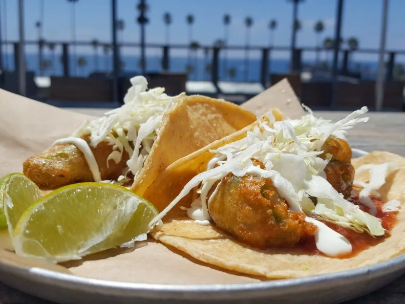 In California, avocados and tacos are each so beloved, they can be considered their own food groups. Get them together in deep-fried glory at Oceanside’s Hello Betty Fish House. The restaurant’s fried avocado tacos are basically a vegetarian riff on the fish taco. Chef Jared Hills batters ripe slices of avocado to fry until golden and crisp. The creamy, crackling hunks of fruit are wrapped in chewy corn tortillas and topped off with cabbage, crema, salsa and a side of limes.