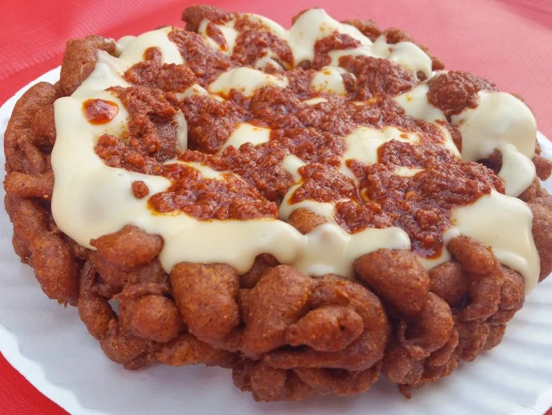 The Iowa State Fair is known for its deep-fried bonanza. It is, of course, the birthplace of the whole stick of butter deep-fried on a stick. (For the record: Plain fried butter was created in Texas.) Best Around Concessions puts sweet and savory spins on fair-favorite funnel cakes, inventing combinations like pineapple inside-out, red velvet and funnel fried bacon, but it’s new cheesy enchilada funnel might just take the cake. This savory treat starts with a less-sweet take on traditional funnel cake batter that’s fried, then topped with chorizo and white queso dip.