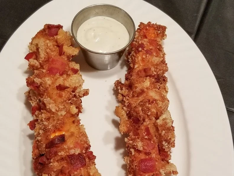 "I love pork rinds," says Vulla Dusek of Dusek Concessions. "And I wanted to do something other than blooming onions." After 20 years in the fair business, the Kansan launched her own concession company for the 2017 Kansas State Fair with the goal of dishing out completely unique deep-fried inventions. Dusek goes whole-hog with an assortment of deep-fried pork rinds in flavors like Cajun, barbecue, sea salt and cayenne, but her cheesy bacon pork rind on a stick is unlike any other porcine creation. Dusek batters and fries a blend of cheddar and mozzarella cheeses on a stick, then rolls the whole thing in deep-fried pork rinds and bacon with a side of ranch dressing.