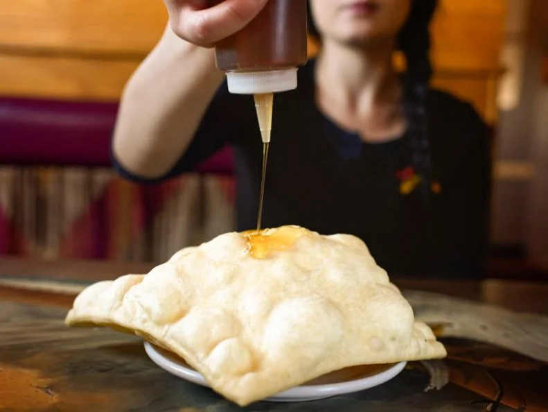 Sopaipillas are an original New Mexican dish that tastes like fry bread and looks like a throw pillow. Cooks across the state (and beyond), form these fluffy squares from simple batter that is dropped into a sputtering deep fryer. In the Land of Enchantment, these doughy cushions are served on the side of entrees or coated with honey for dessert. One of the best places to try sopaipillas is La Cocina in Truth or Consequences, New Mexico. The cloud-like pastries are so big, the corners hang over the side of the plates. Guests eat them alongside the restaurantâ  s classic New Mexican plates.