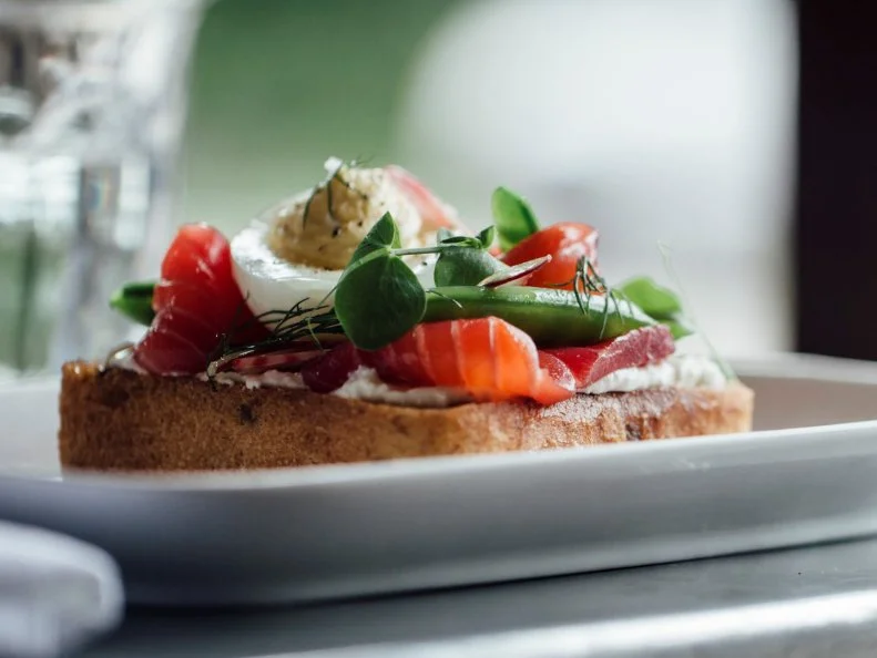 Whether youâ  re having a late lunch with an old friend or a dinner to celebrate a milestone, South Minneapolisâ   St. Genevieve will transport you beyond her plaster walls on a culinary journey. The experience is made all the more enjoyable by the kitchen brigade, led by Chef-Owner Steven Brown, who expertly produce Parisian-inspired food that is at once familiar and innovative, contemporary and thoughtfully sourced. Enjoy the rabbit ravioli with carrots, or the salmon tartine, with beet-cured salmon that looks so beautiful you almost donâ  t want to eat it. You will, of course, and perhaps enjoy it with bubbles. St. Genevieve has an extensive Champagne-by-the-glass program and a wine list that focuses on the smaller, lesser-known regions of France. Bon appÃ©tit!