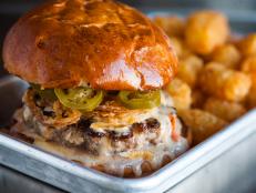 There are many good burgers in town, but you can grab a truly great one for 11 bucks at this hip retro spot. Inspired by a favorite fast-food burger, owner Wes Rowe created The Hot Wes by stacking a magical combination of crisp onion rings and spicy pickled jalapeños on a six-ounce patty smothered in gooey queso. Order it at lunchtime for this golden bonus: a heaping portion of potato tots served on the side.