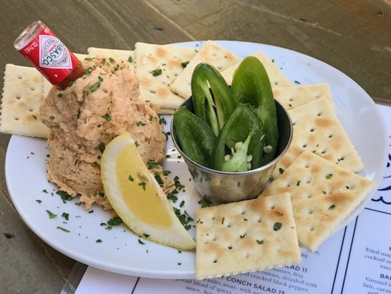 Florida’s proximity to the water — and its bountiful seafood supply — means that fish and its many preparations figure prominently in local diets. Miami restaurateur Matthew Kuscher shares that after a fishing trip, any leftover or smaller fish are smoked and often crafted into a dip. At casual Miami seafood-focused spot The Spillover, Chef Spider Harris smokes locally caught snapper, wahoo and grouper in-house for the Florida Fish Dip, mixing the lot with salt, sour cream, mayo and Sriracha to achieve a smoky-with-a-kick flavor and a firm but creamy texture. Accompaniments include Saltine crackers, mini bottles of Tabasco and sliced jalapenos to customize your bite.