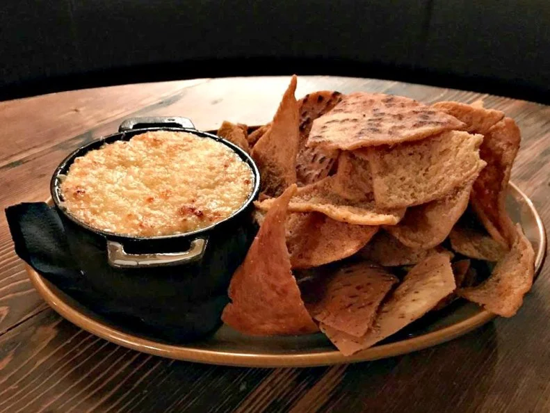 Lobster and crab are two of New Englandâ  s most-prized treasures, which says a lot in a state that elevates local sports stars to hero status. Across the region the shellfish shine solo when theyâ  re steamed or boiled, but when they team up in the Lobster & Crab Dip at PARK Restaurant & Bar in Cambridge, theyâ  re destined for legendary New England status. The dipâ  s been a fixture on the Harvard Square restaurantâ  s menu from day one and remains one of the most-popular dishes. Generous chunks of local lobster and crab are folded into a blend of minced onions, sour cream and Tabasco, topped with nutty Gruyere cheese and baked in a cast-iron crock until blistered and bubbly. The rich, creamy dip is served with a side of pita chips seasoned with oregano and Old Bay.