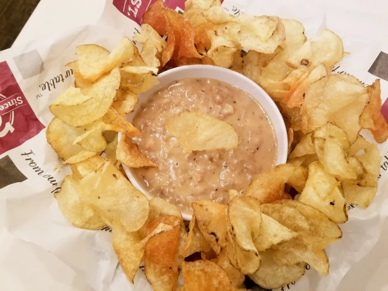 Located in the state capital of Bismarck, landmark restaurant Peacock Alley has hosted its fair share of political superstars, as seen in the photographs lining the wall. But whether you’re a U.S. president or a local regular, few can resist the lure of Peacock Alley’s bacon gravy dip. When the kitchen first blended the house bacon burger into a gravy, it was intended to be served alongside breakfast skillets. But it quickly became a hit amongst staff who used it as a dip for potato chips. Now everyone can get their fill of the homemade chips and hot gravy, which features ground, sliced bacon and lean beef, sautéed until crumbly and finished with a top-secret seasoning blend, demi-glace and cream. The thick and creamy dip has become so popular, diners order extra to top waffles, steaks and other dishes.