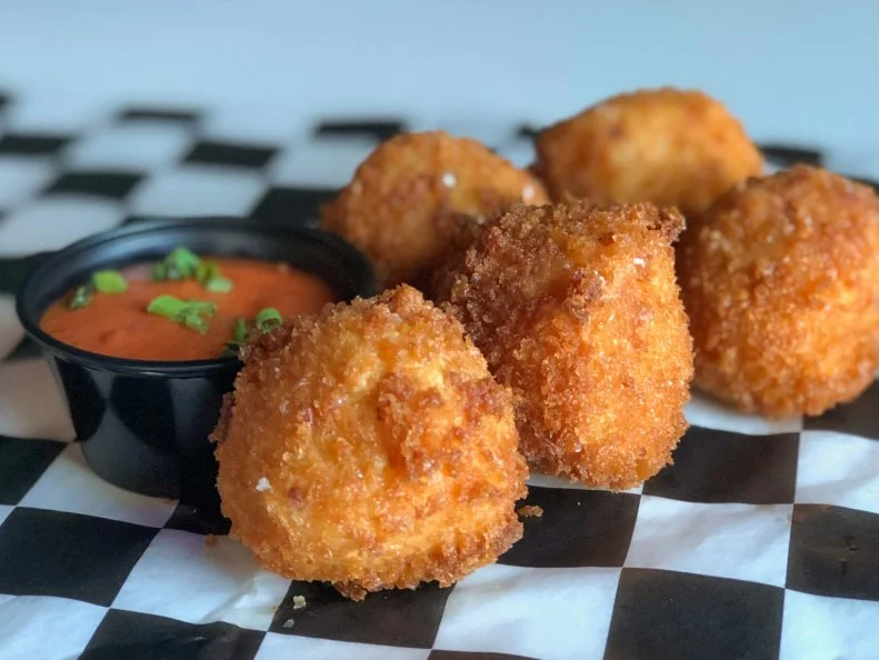 Rhode Islanders love a good cocktail and are particularly fanatic about brunch, so Ogie’s Trailer Park brings a little Sunday funday flair to its comfort food menu, pairing the mac and cheese croquettes with a Bloody-Mary-Nara dipping sauce. The marinara component of the sauce is taken particularly seriously, since the restaurant is close to Providence’s Federal Hill neighborhood, home to a large Italian American community. Their house-made red sauce is bolstered with a secret blend of herbs and spices and blended with the bar’s Bloody Mary mix to create a tangy-spicy dipping sauce, perfect for cutting the richness of the mac and cheese croquettes.