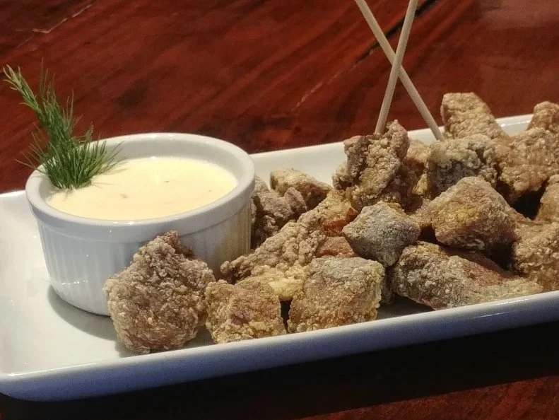 In South Dakota, some argue that chislic – chopped, deep-fried meat – is only truly chislic if it’s made with lamb, but it’s also common to make it with game, including pheasant or venison. At Ode to Food and Drinks, the preparation is unconventional across the board; chopped sirloin is dredged in egg whites and cornstarch for crunch before getting the deep fryer treatment. Instead of serving it with the typical barbecue or ranch sauces, the kitchen serves chislic with ghost cheese dip. The warm dip features a blend of shallots, celery, sour cream, cream cheese, heavy whipping cream, and ghost cheese, a Monterey Jack cheese studded with super-hot ghost peppers. The dip is so popular, it’s also served on the chimichanga, and diners order extra to top mashed potatoes or use as fry dip.