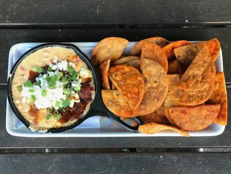 Whether you call it pimento or pimiento cheese, the dip is a ubiquitous Southern staple in homes and restaurants. But at Knoxville burger-and-bourbon spot The Stock & Barrel, the dip is baked, for near-legendary results. The cheddar-cheese-mayo dip already made for a stellar burger topping, but the team was inspired to create an appetizer with it. When baked in a skillet topped with layers of goat cheese and tomato jam, the pimento cheese â   a blend of shredded barrel-aged white cheddar, mayonnaise, cream cheese and diced pimentos â   becomes a warm, tangy comfort, perfect for scooping with pita chips. Pair it with a bourbon flight for a true taste of the region.