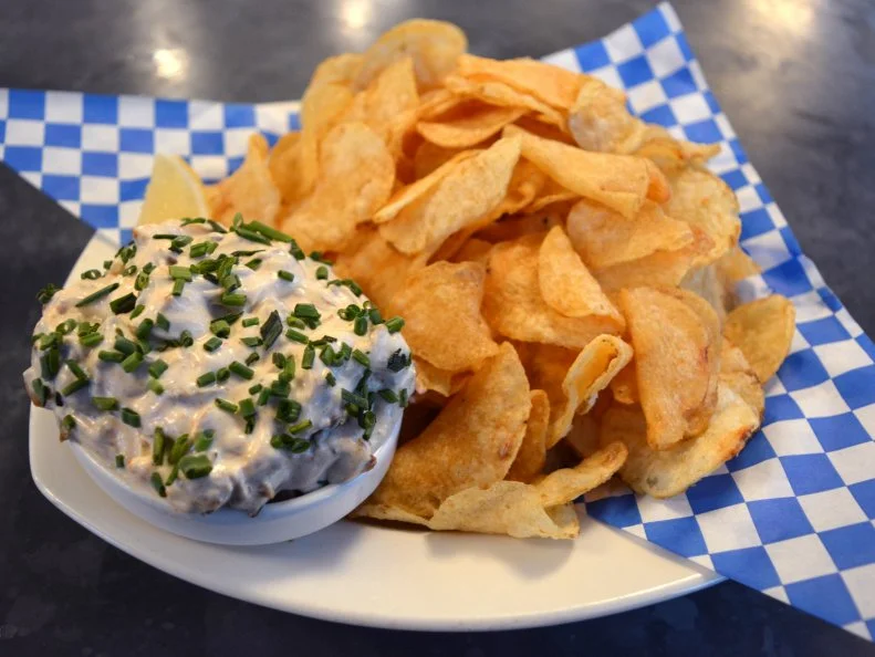 When it comes to seafood dips, Washington is downright spoiled. Its location in the Pacific Northwest means that smoked salmon, crab and lobster dips abound on restaurant menus, but localsâ   favorite contribution to the stateâ  s dip canon is Taylor Shellfish Farmsâ   smoked oyster dip. The fifth-generation shellfish company cultivates a variety of shellfish, including several kinds of oysters, and showcases their bounty at Taylor Shellfish Oyster Bars. When they opened their original location on Capitol Hill, the space had limited cooking options â   so in addition to serving freshly shucked raw oysters, the team put their smoker to good use and created a smoked oyster dip. The smoky, creamy dip features Pacific oysters from Willapa Bay that are steamed, brined and smoked over maple chips before being folded with Mexican crema, mayo and a secret blend of spices, all served with kettle-cooked potato chips.