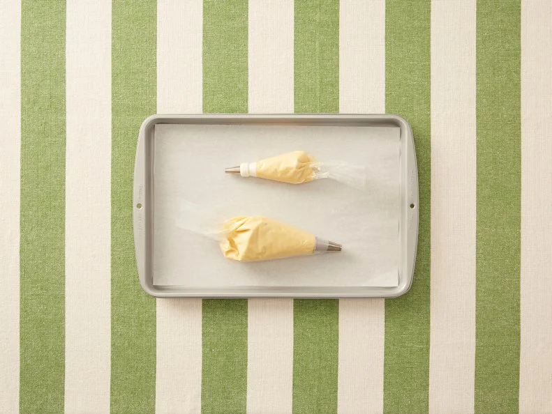 Making Cream Puff Animals - Cream Puff Swan: Piping dough into shapes, then baking, slicing, and filling with pastry cream to create cream puff swans for Eatertainment, as seen on Kids Baking Championship, Season 2.