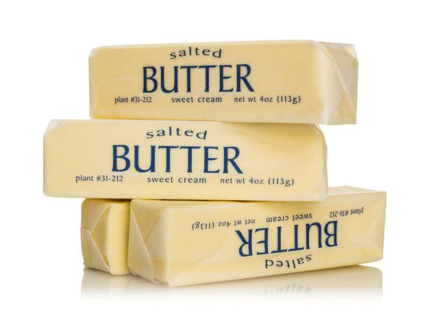 Four sticks of salted butter isolated on white.