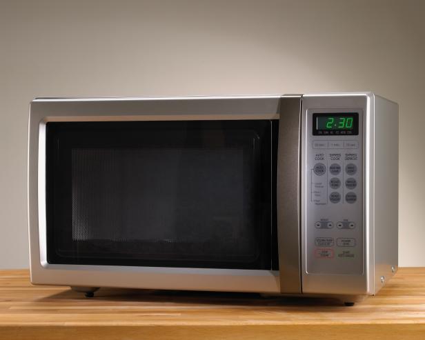 Microwave oven on wooden table with time displayed