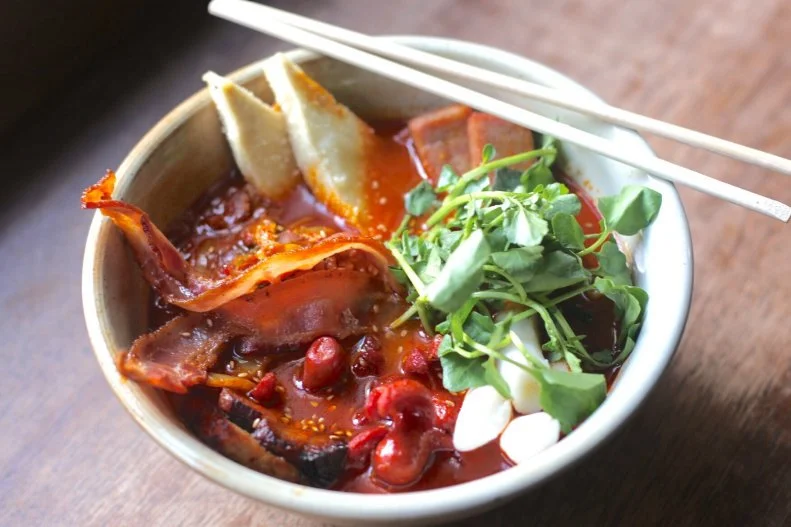 Mokbar chef-owner and Food Network Kitchen alum Esther Choi grew up cooking traditional Korean food with her grandmother. One of her most-popular bowls of ramen is inspired by the popular Korean dish army stew, or budae jjigae, which is made from kimchi, ham, sausage, Spam, baked beans and other canned products. The original stew was made in Korea from U.S. Army base rations in the postwar period when food was scarce. Choi's version is made from 8-to-10-hour tonkotsu broth, a special spicy gochujang paste mix and fresh ramen noodles, topped with stewed bacon, kimchi, Spam, sausage, tofu, pork belly, mozzarella cheese and watercress.