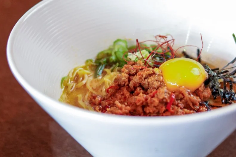 Open since April 2018, Moshi Moshi (named for the typical greeting in Japanese) is a ramen spot where many of the ingredients, including noodles, sauces and condiments, are made in-house. The ramen is made with a tonkotsu shoyu broth that is fortified with a tare, a type of dipping sauce that has sweet and sour notes from housemade vinegar and palm sugar. The bowl is topped with aka miso and wagiri chile ground pork, and finished with an egg yolk, toki togarashi seasoning, rayu Japanese chili oil and shredded nori.