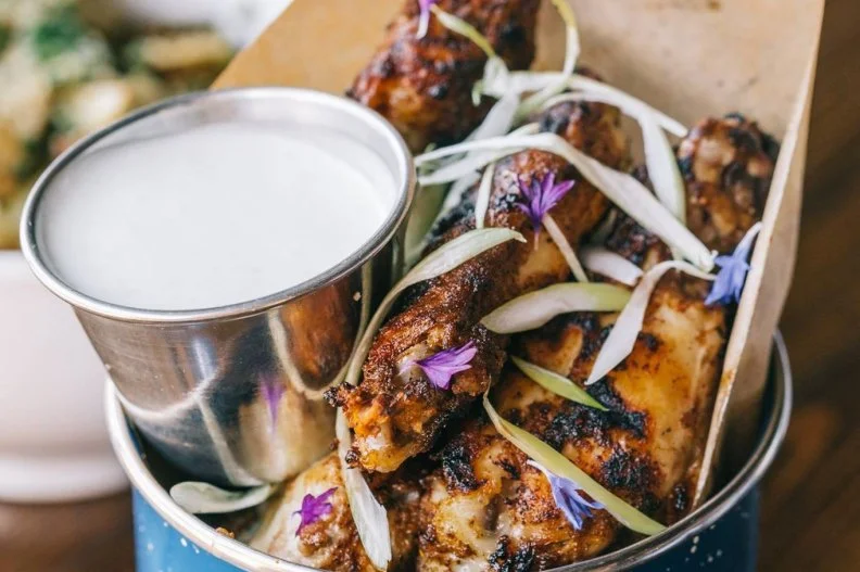If you love Caribbean spices, you'll love the jerk wings at this Detroit locale. The wings are first bathed in a wet jerk marinade for 24 hours before being cooked for 12 hours. They are then grilled with a dry jerk seasoning â   think flavors of allspice, ginger, garlic and chipotle â   and plated alongside an applewood-smoked blue cheese dressing.