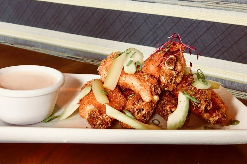This all-glass restaurant is a must for its sights and also for the food. The bar menu is where you'll find the chicken wings, which are tossed in 8UP's signature dry rub and topped with pickled celery and scallion. The kitchen here takes the classic ranch dressing side and elevates it with flavors of chipotle and lime — creating the perfect dipper for the wings.