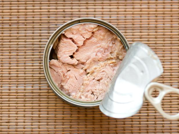 Tinned Tuna Fish. Ready for eat without cooking On a bamboo straw kitchen utensil surface.