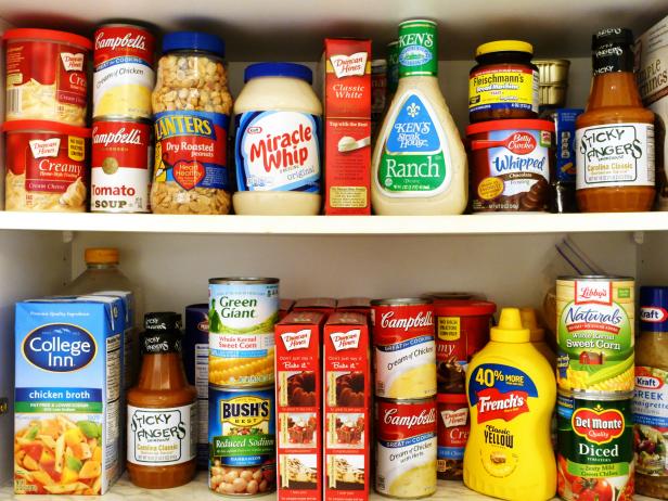 West Palm Beach, USA - October 9, 2015: Image of two kitchen pantry shelves filled with groceries. Included among the groceries are canned soups, tomatoes, beans and corn, salad dressings, barbecue sauce, peanuts, mustard, cake mixes, chicken broth, and a variety of other cooking and baking ingredients. Many popular brand names are represented, such as Campbells, Green Giant, Del Monte, Bush's, Miracle Whip, Betty Crocker, Libbys, Duncan Hines and Kraft