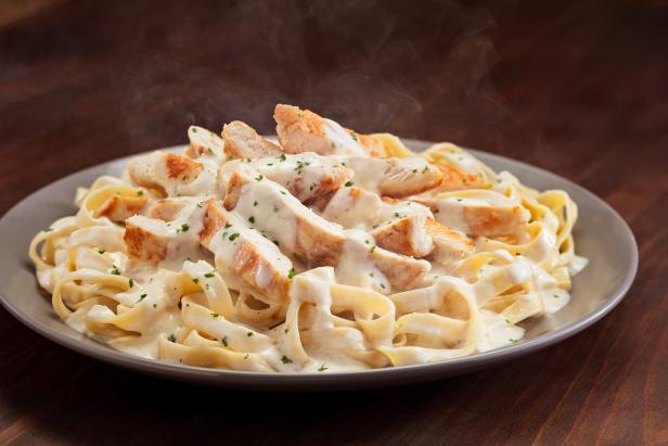 With dozens of mix-and-match pasta possibilities (or, should we say, pastabilities), it's the big, creamy bowl of Olive Garden's Chicken Alfredo that continues to top the restaurant's list of most-popular entrees. Sliced grilled chicken is served over tender fettuccine pasta and doused in OG's signature homemade Alfredo sauce, which is made from scratch daily. We think that's exactly what the restaurant's iconic breadsticks are for — mopping up all that rich cream sauce.